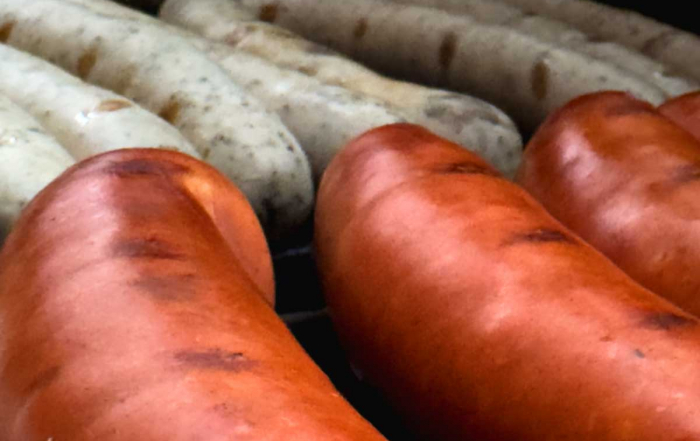 Würstchen mit leichten Grillstreifen auf einem Grill, dicht an dicht