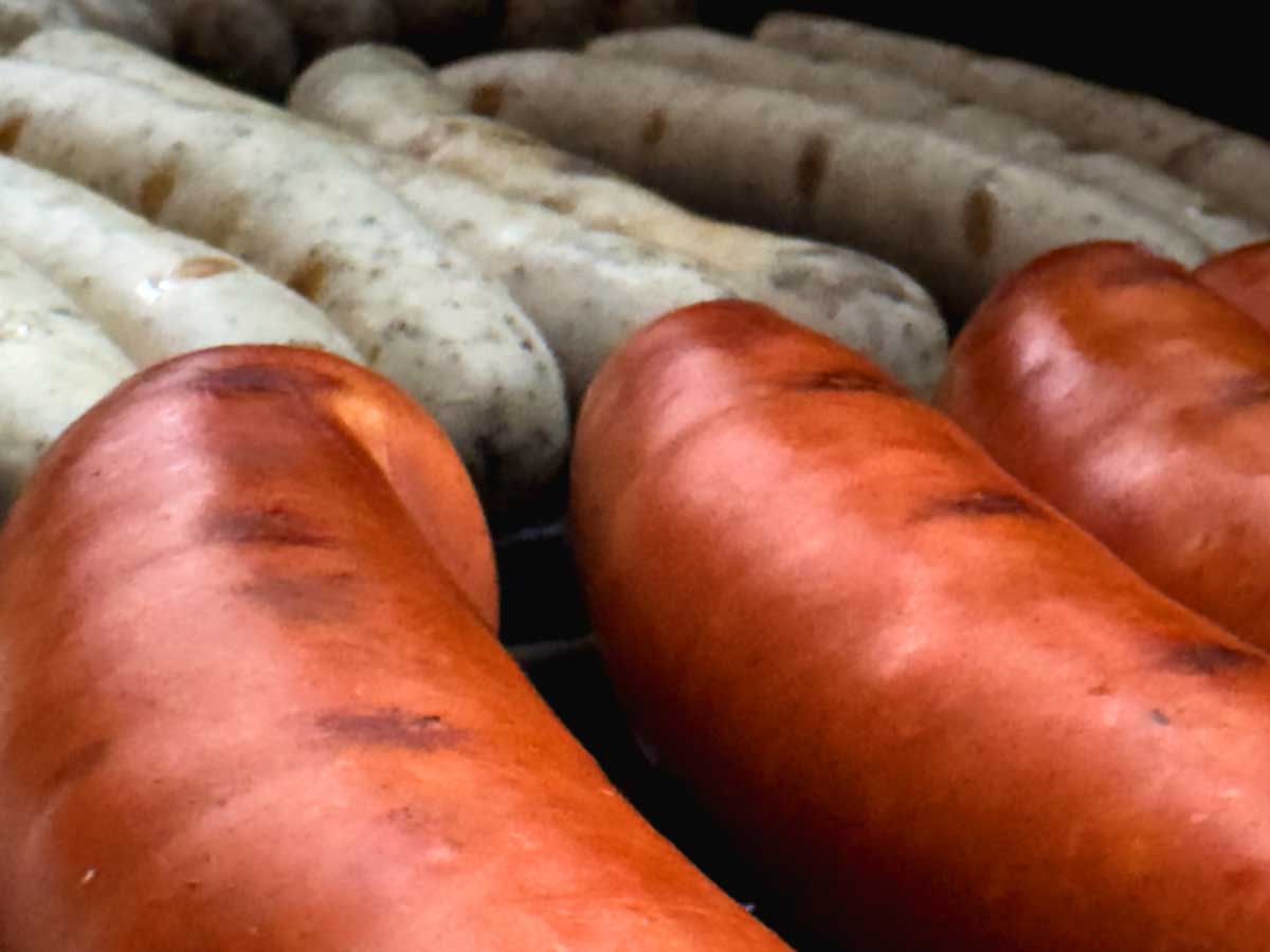 Würstchen mit leichten Grillstreifen auf einem Grill, dicht an dicht